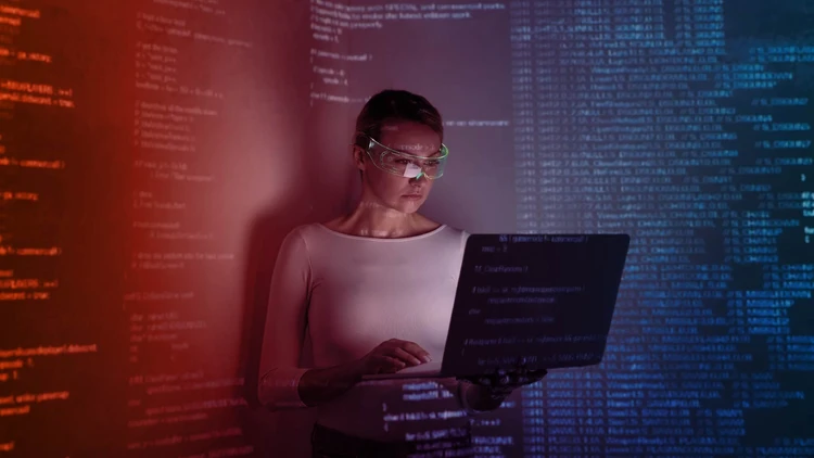 Una professionista che utilizza tecnologie avanzate di data & ai visualizzando stringhe di codice e flussi di dati complessi proiettati su uno schermo e nell'ambiente circostante.