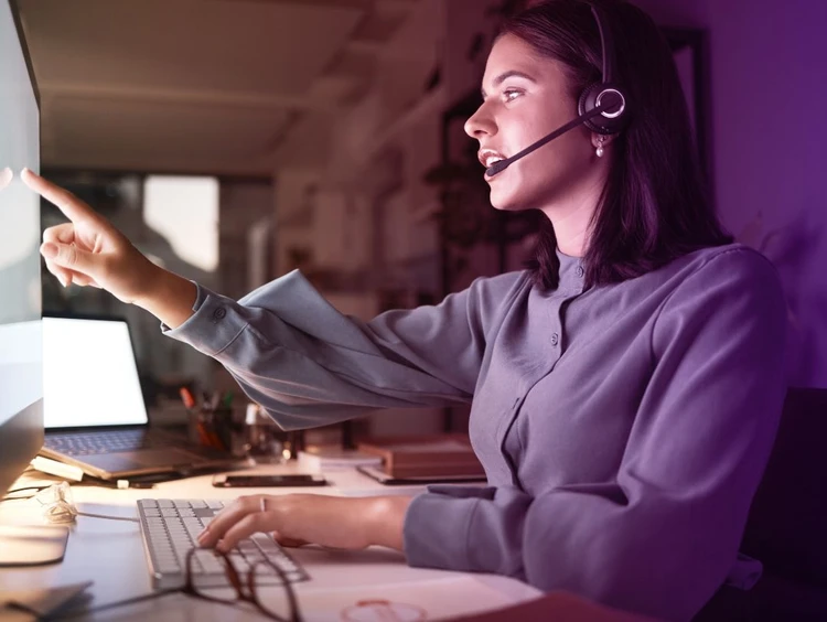 Una donna con le cuffie lavora al pc